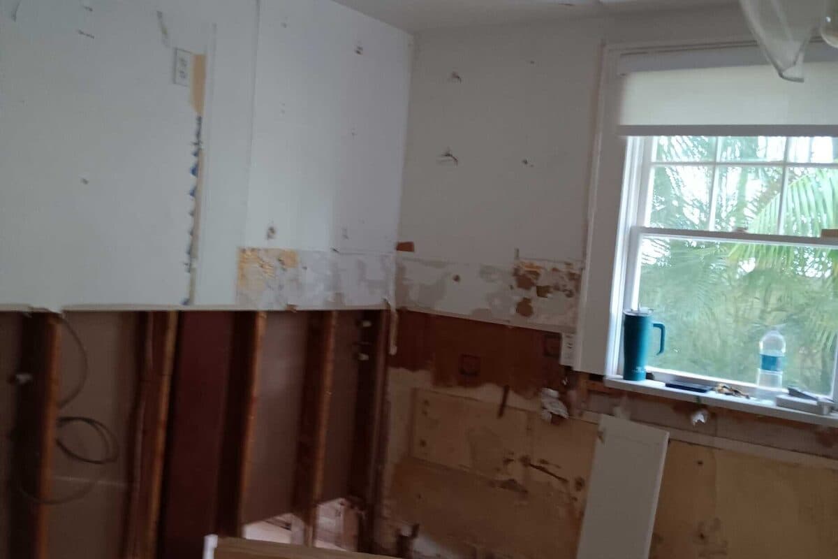 Kitchen gut demo in an older St. Petersburg home, exposed framing and original plumbing visible