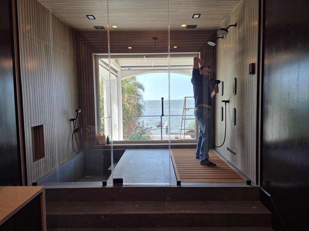 In-progress commercial bathroom shower installation with ADA-compliant plumbing rough-in