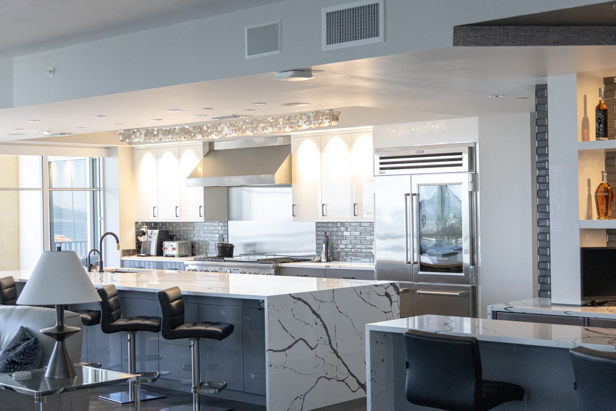 Luxury condo kitchen with waterfall quartz island and evening lighting in downtown St. Petersburg