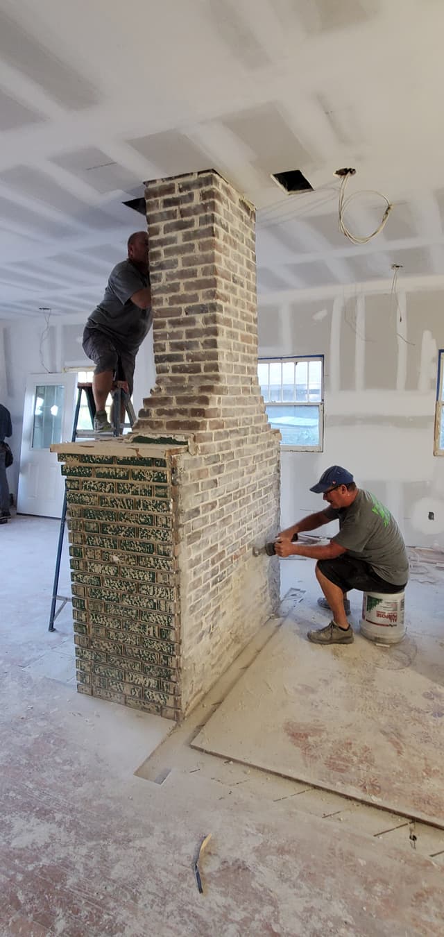 Historic brick fireplace being restored in a St. Petersburg bungalow renovation