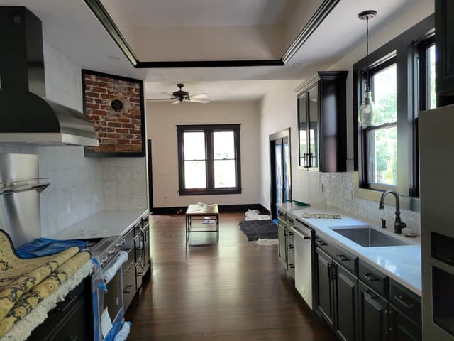 Renovated historic kitchen with dark cabinets and exposed brick in St. Petersburg