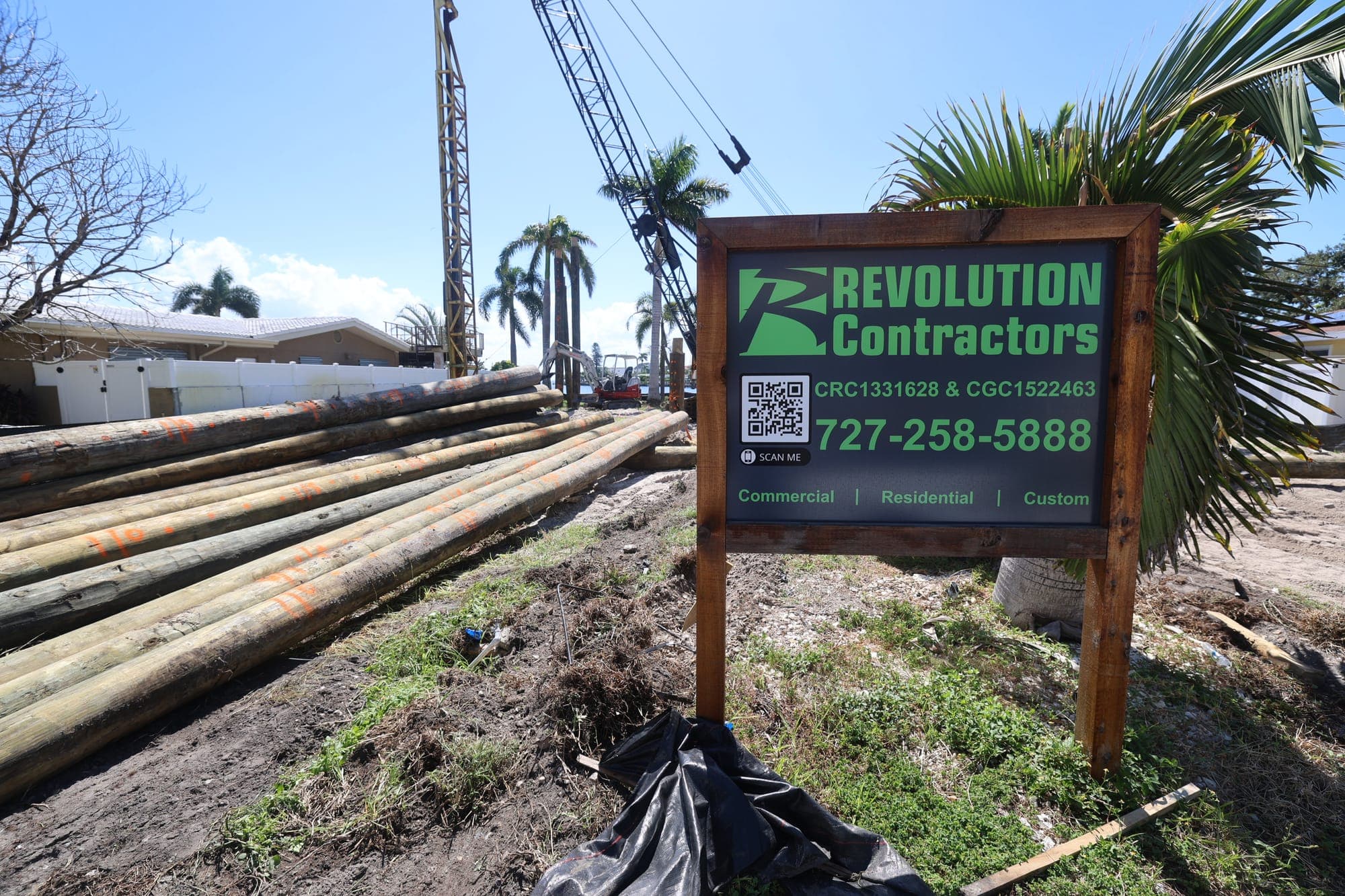 Custom home site work with Revolution Contractors sign and crane in St. Petersburg