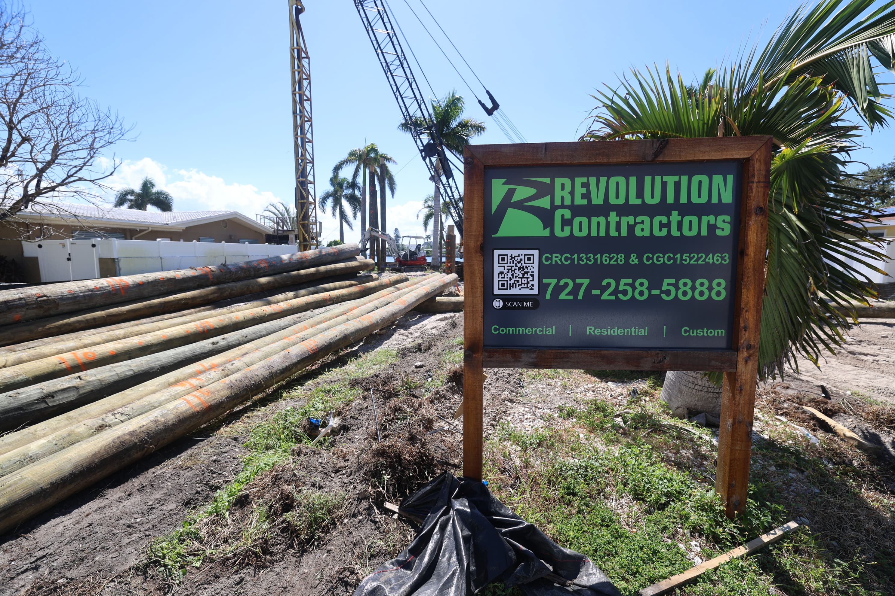 Custom home site work with Revolution Contractors sign and crane in St. Petersburg
