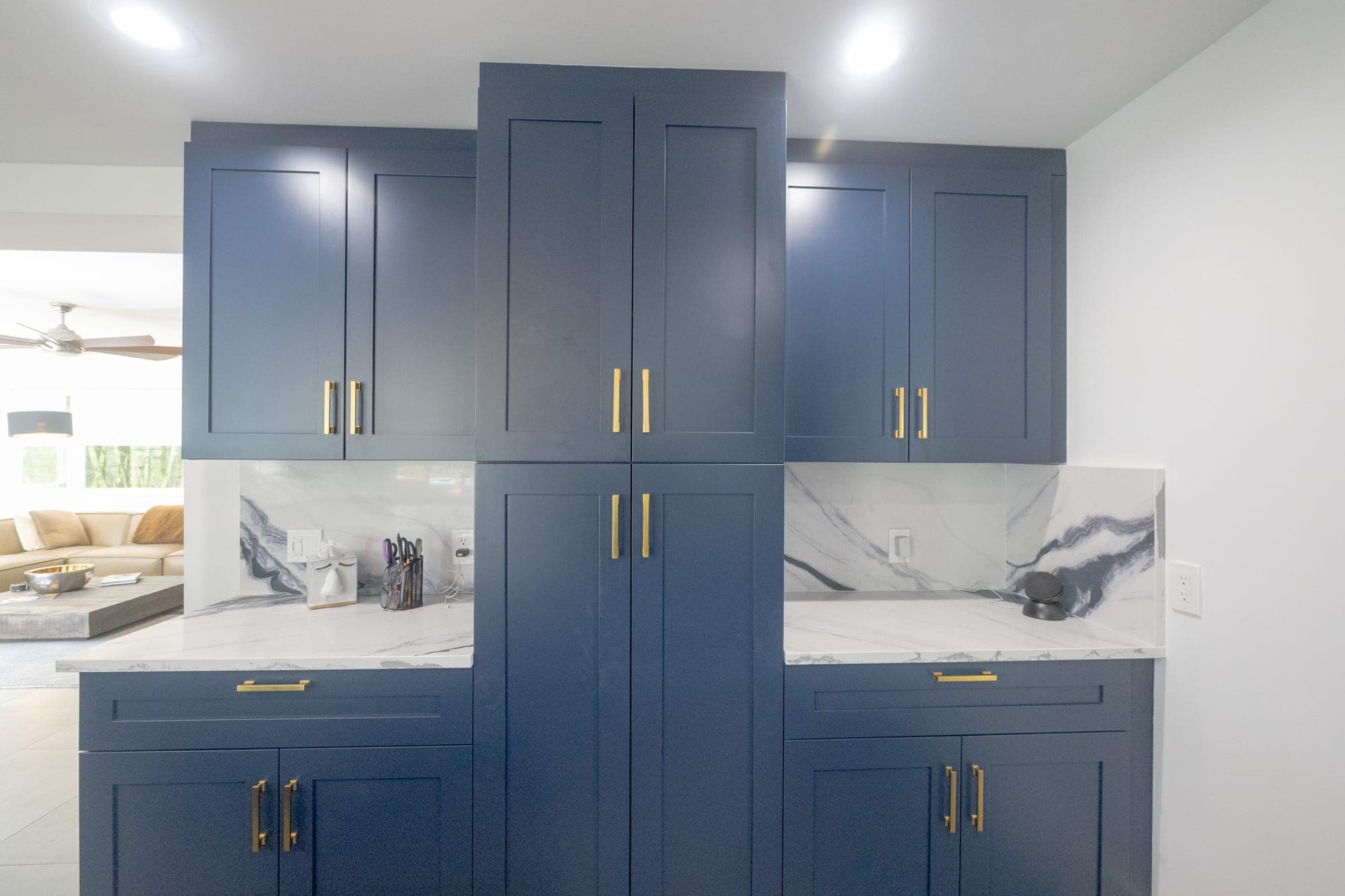 Modernized kitchen with navy cabinets and marble backsplash in a Coffeepot Bayou bungalow