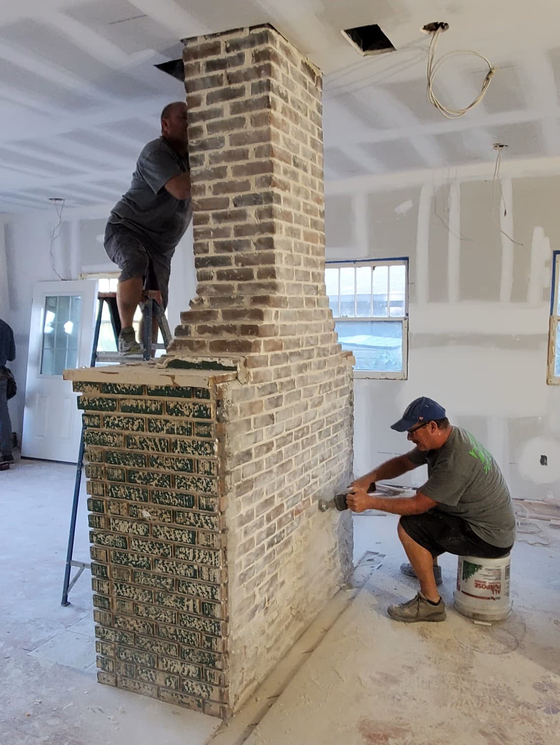 Brick fireplace mid-restoration with walls opened around the firebox for new structural framing — 175 19th Ave SE Old Southeast historic bungalow restoration