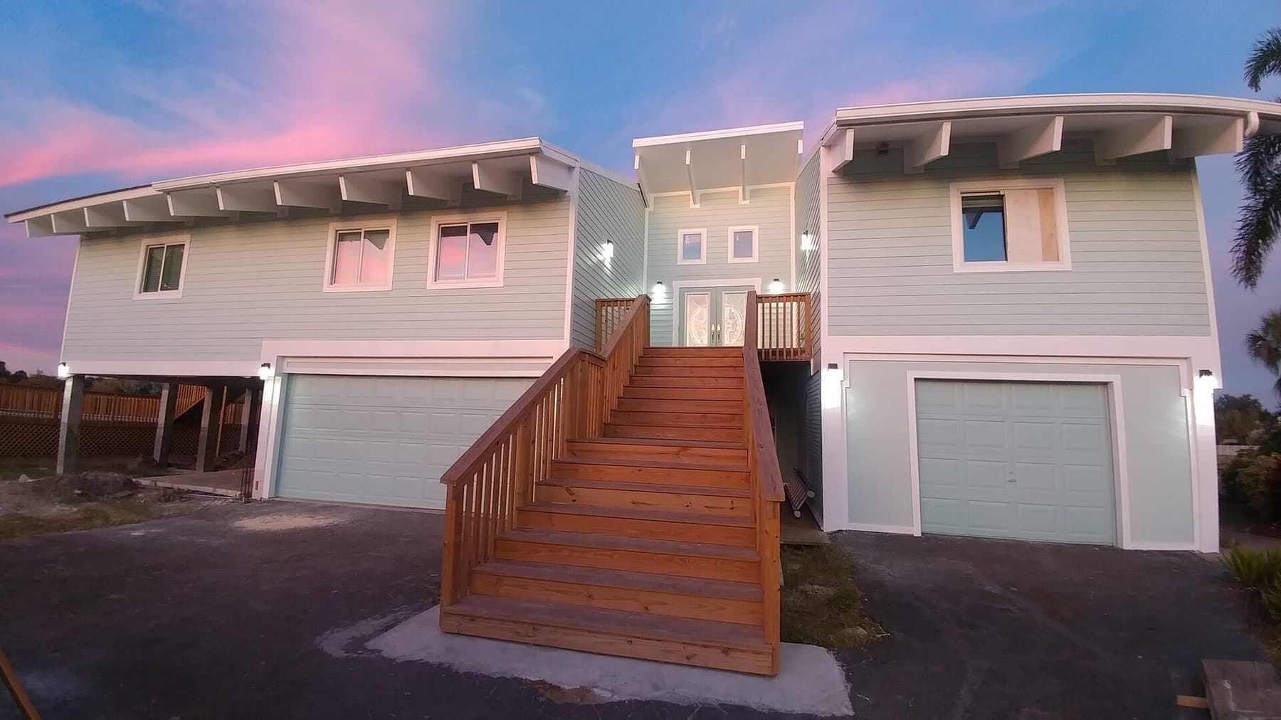 Bahama Avenue home after Revolution renovation, elevated coastal build with cedar staircase and modern butterfly roofline