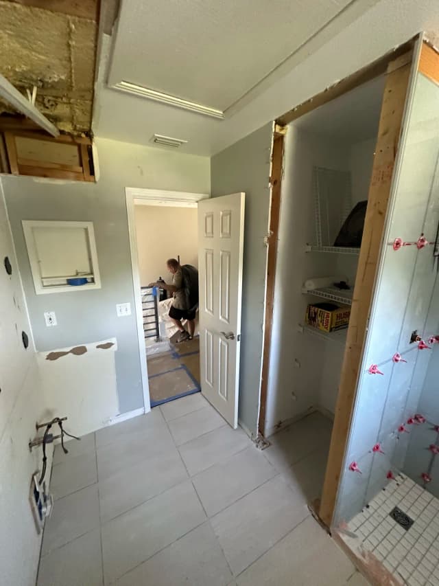 Bathroom tile installation in progress — Revolution Contractors crew on a St. Pete project