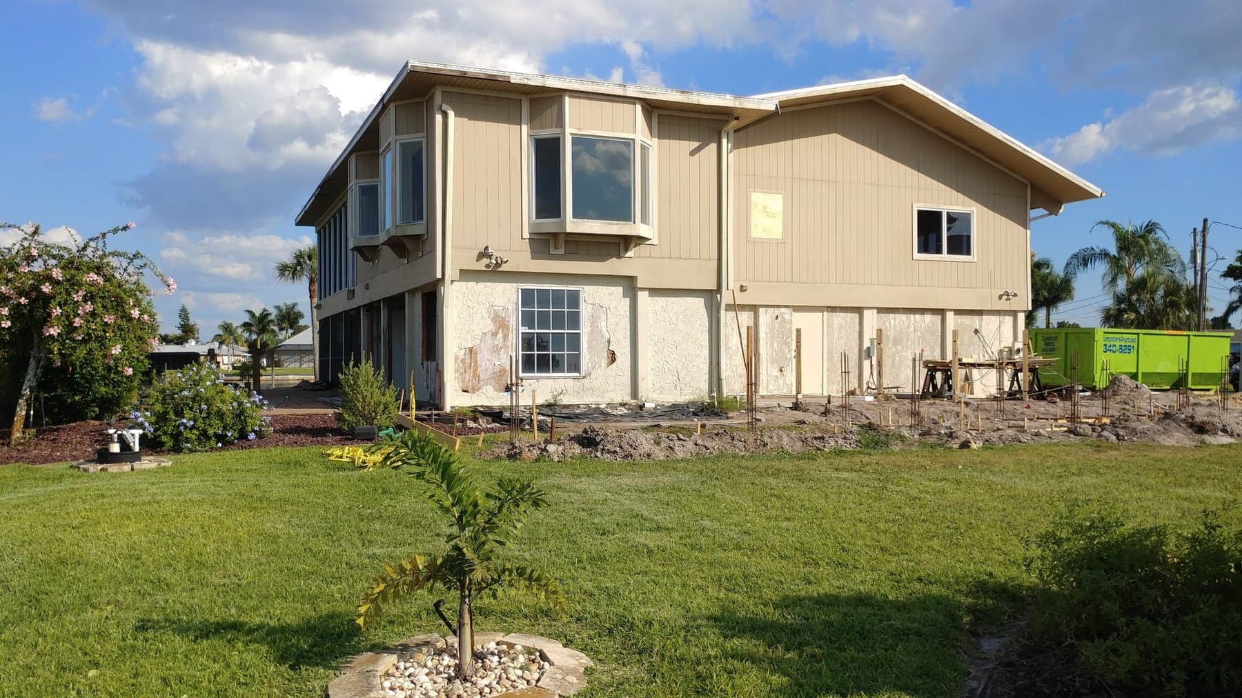 Bahama Avenue home before renovation, deteriorated lower level, damaged siding, pre-construction