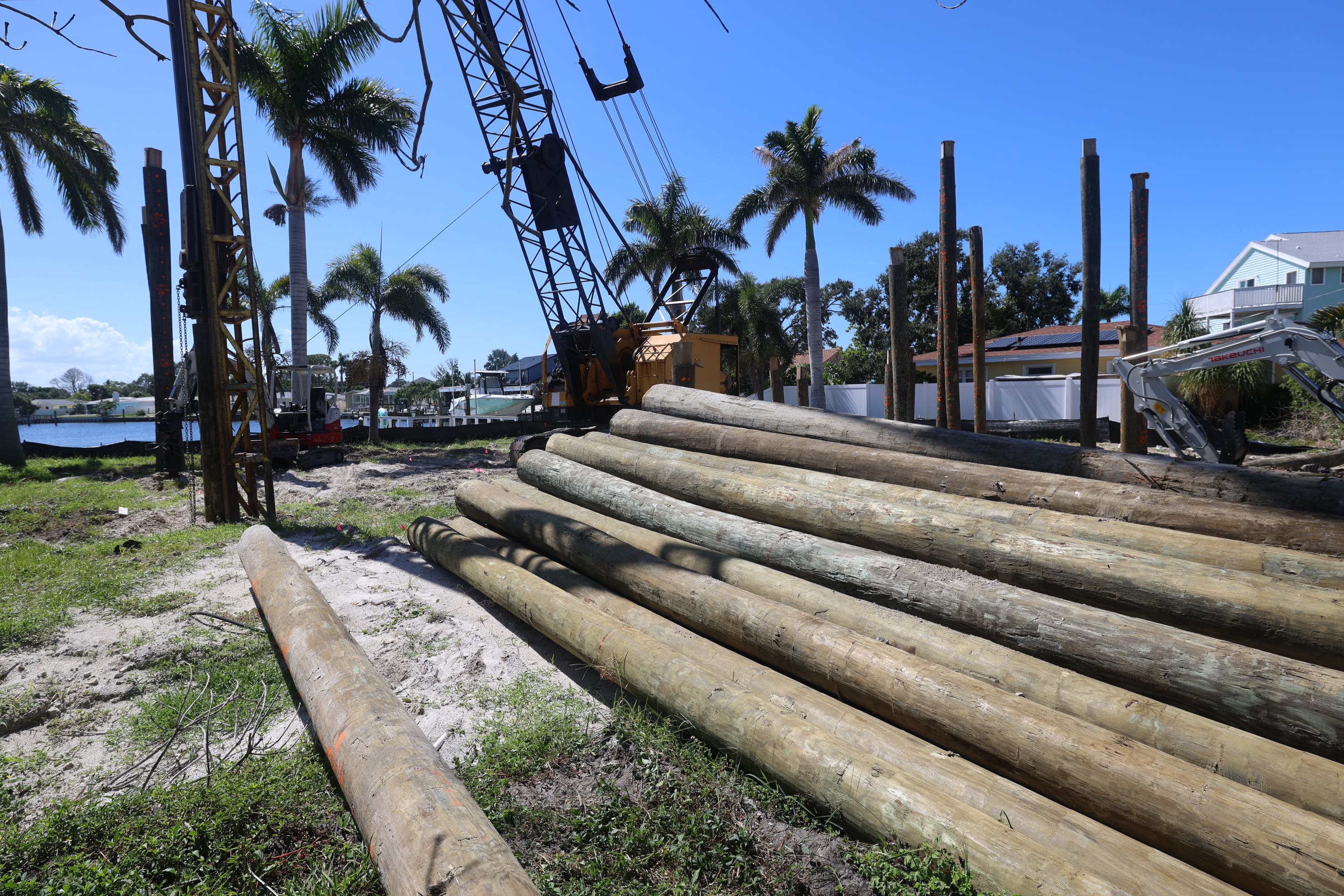 Santos piledriving — timber pilings and crane on a waterfront lot in St. Petersburg